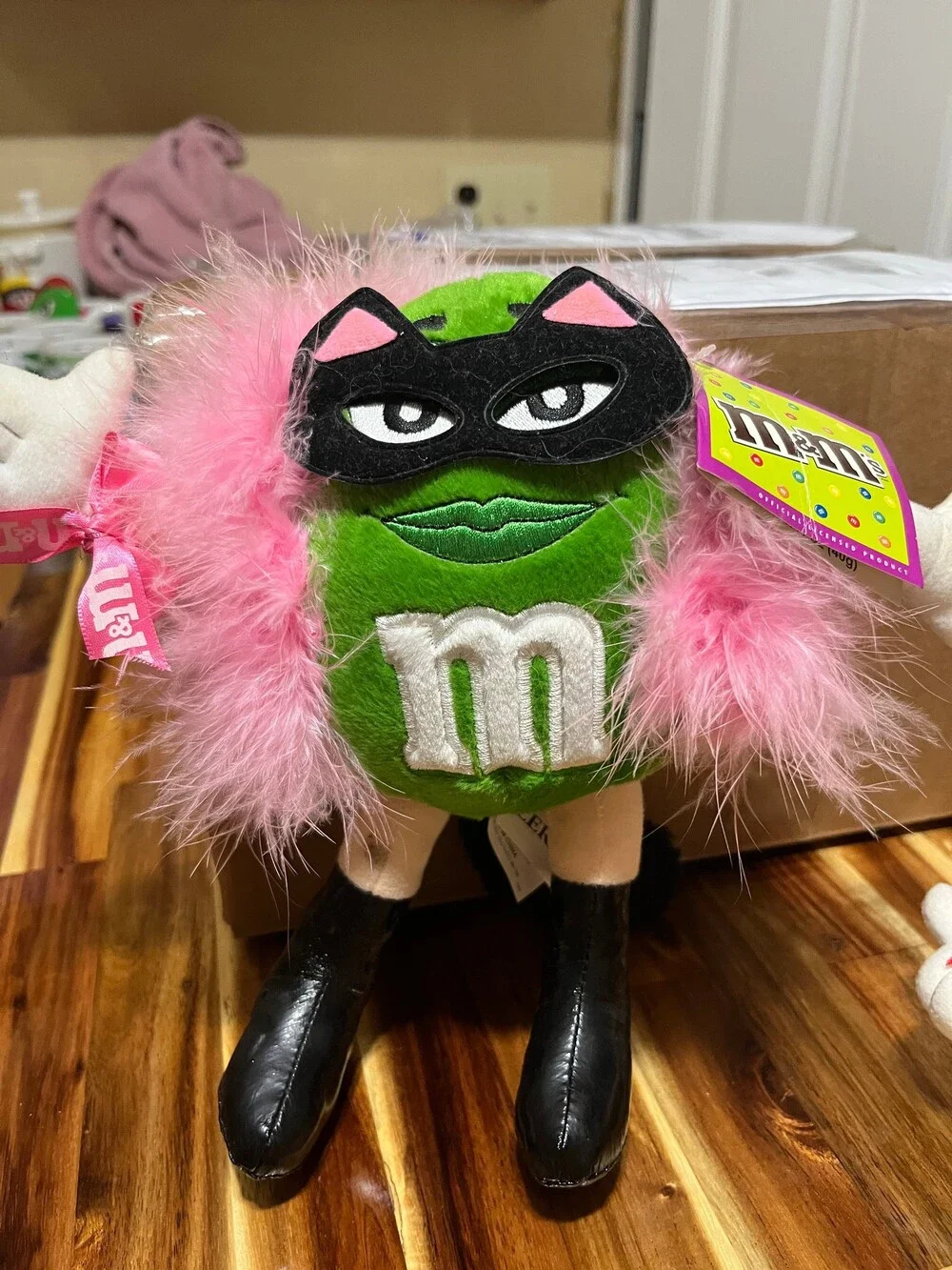 M&M's Green Character Plush dressed up as cat women with Pink Feather Boa Plush
